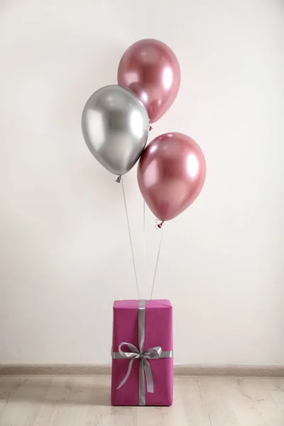 Presentförpackning Och Ballonger Nära Vit Vägg — Stockfoto