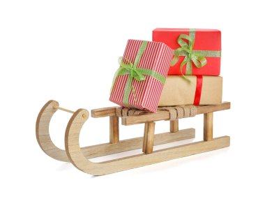 Beyaz arka planda Noel hediyesi kutuları olan tahta kızak.
