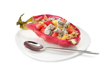 Beyaz arka planda kaşık yanında mango, granola ve çilekli nefis pitahaya teknesi.
