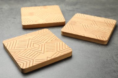 Gri masadaki ahşap bardak altlıkları.