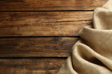 Tahta masa üzerinde doğal çuval bezi kumaşı, üst manzara. Metin için boşluk