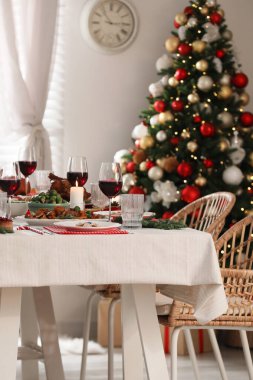 İçerideki masada lezzetli yemek ve şarapla şenlikli bir akşam yemeği. Noel arifesi
