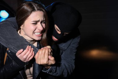 Gece vakti kendini saldırganlardan koruyan bir kadın.