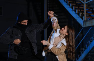 Kadın hırsızla kavga ederken adam gece dışarıda çantasını çalmaya çalışıyor. Nefsi müdafaa