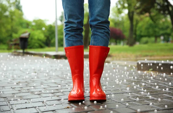 雹と雷雨の後 屋外で赤いゴム製のブーツを身に着けている女性 クローズアップ — ストック写真
