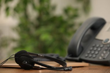 Kulaklık, masaüstü telefonu ve dizüstü bilgisayar kapalı masa, mesaj için yer. Yardım hattı kavramı