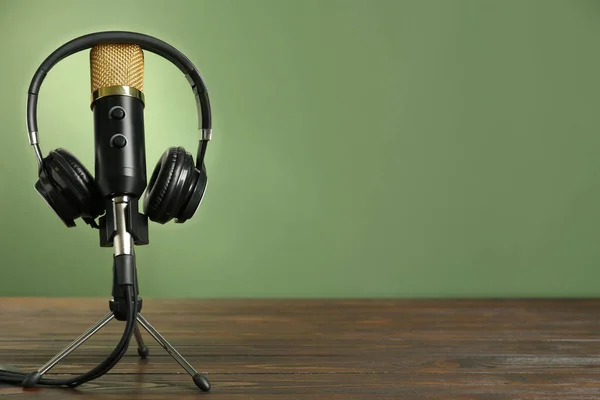 Mikrofon Och Moderna Hörlurar Träbord Mot Grön Bakgrund Utrymme För — Stockfoto