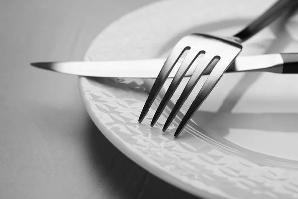 Πιάτο Πιρούνι Και Μαχαίρι Γκρι Τραπέζι Closeup — Φωτογραφία Αρχείου