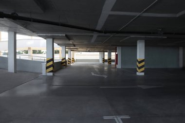 Sütunlarda uyarı çizgileri olan boş açık araba otoparkı