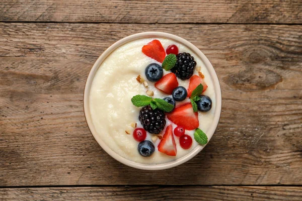 Ahşap masadaki böğürtlenli leziz irmik pudingi.