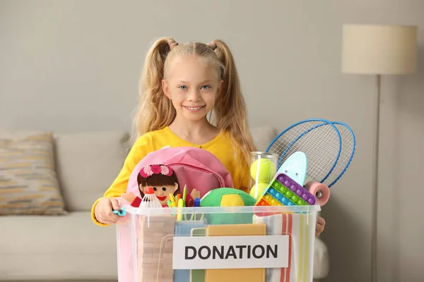 Милая Маленькая Девочка Держит Коробку Пожертвований Игрушками Дома — стоковое фото