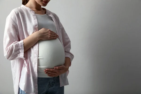 Açık Gri Arka Planda Genç Hamile Bir Kadın Yakın Plan — Stok fotoğraf