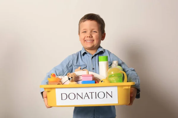 可爱的小男孩拿着装有轻型背景物品和玩具的捐赠盒 — 图库照片