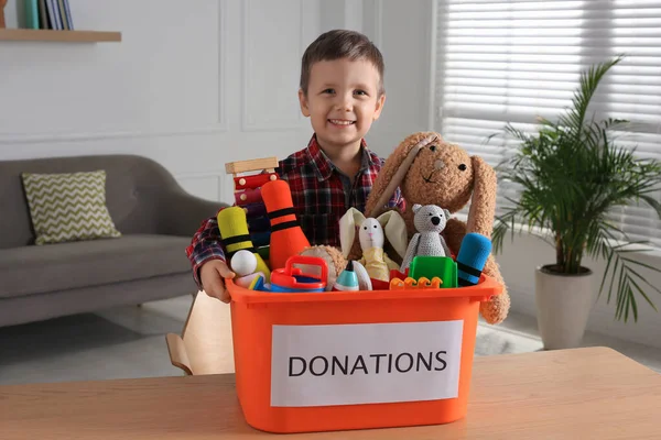 可爱的小男孩在家里拿着装有玩具的捐赠盒 — 图库照片