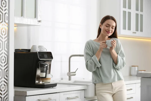 Mujer Joven Disfrutando Café Aromático Fresco Cerca Máquina Moderna Cocina —  Fotos de Stock