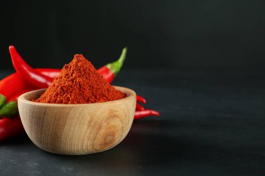 Paprika tozu ve taze biberler siyah masada. Metin için boşluk