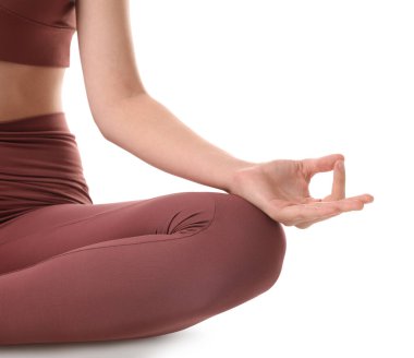 Spor kıyafetli bir kadın beyaz arka plan üzerinde meditasyon yapıyor, yakın plan.