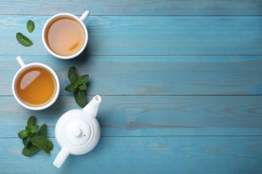Açık mavi ahşap masa üzerinde sıcak aromatik nane çayı, düz uzanmış. Metin için boşluk
