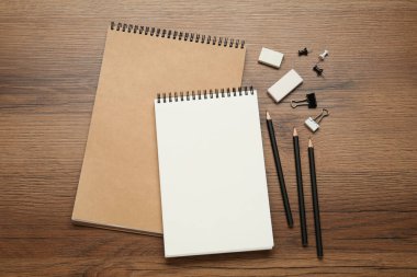 Çizim defterleri ve ahşap masanın üzerinde duran düz kompozisyon