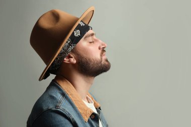Gri arka planda bandanası olan şık giyinmiş şık genç adam, mesaj için yer var.