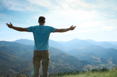 Güneşli bir günde, dağlarda bir turist.