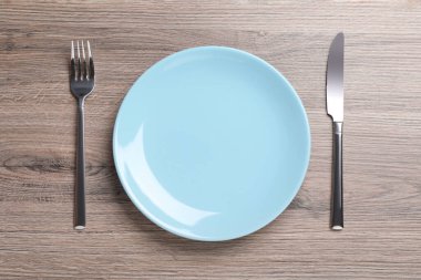 Parlak gümüş çatal ve bıçakla kaplı bir tabak.