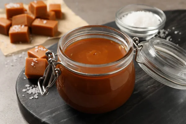 Tasty Salted Caramel Glass Jar Grey Table Closeup — Stockfoto