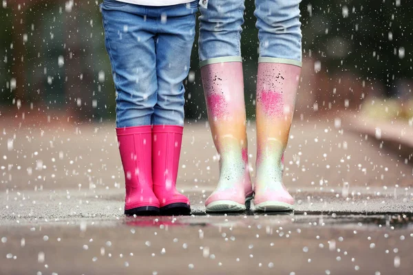 母と娘は雨の日にゴム製のブーツを着て雹と クローズアップ — ストック写真