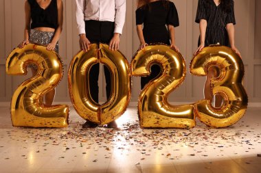 Kapalı alanda 2023 balonlu arkadaşlar, yakın plan. Yeni yıl kutlaması