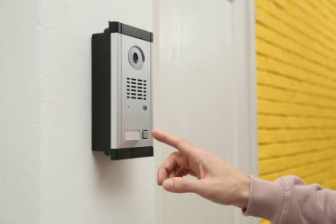 Girişteki kameralı dahili telefonu çalan adam, yakın plan.