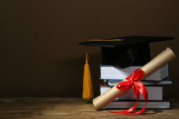 Mezuniyet Şapkası Kitaplar Diploma Ahşap Masa Üzerinde Kahverengi Arka Plan — Stok fotoğraf