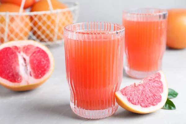 Leckerer Frisch Gemachter Grapefruitsaft Und Obst Auf Hellgrauem Marmortisch — Stockfoto