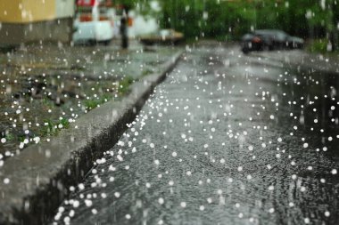 Yağmurlu bir günde şehir caddesinin manzarası dolu dolu yağarken