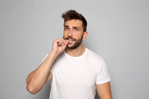 Man Biting His Nails Grey Background — Stock Photo, Image