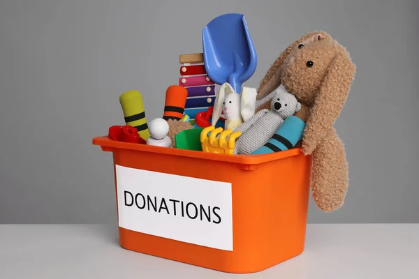 Donation Box Different Toys White Table Grey Background — 图库照片