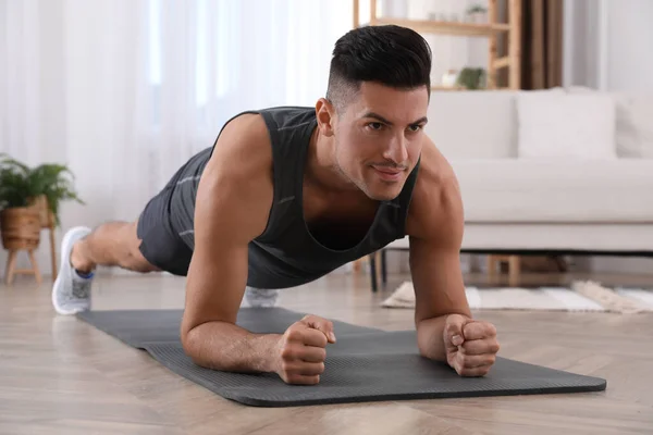 Hombre Guapo Haciendo Ejercicio Tablón Alfombra Yoga Casa — Foto de Stock