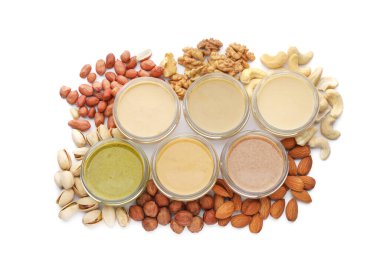 Beyaz arka planda farklı fındıklardan yapılmış tereyağlı kavanozlar, üst görünüm