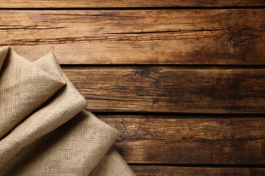 Tahta masa üzerinde doğal çuval bezi kumaşı, üst manzara. Metin için boşluk