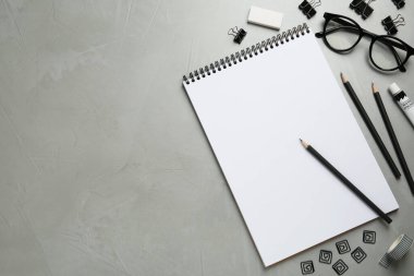 Çizim defteri, gözlük ve durağan ile açık gri tablo üzerinde düz kompozisyon, metin için boşluk