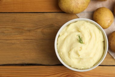 Yeni pişirilmiş ev yapımı patates püresi ve ahşap masada çiğ sebzeler. Metin için boşluk