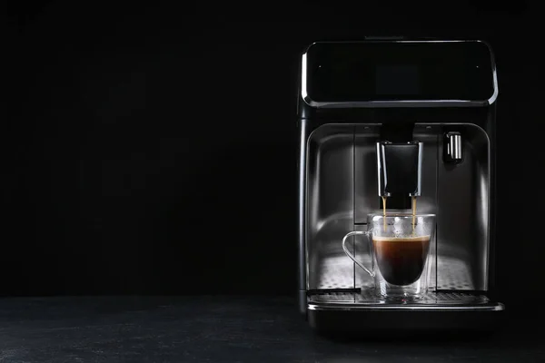 黒を背景にグレーのテーブルの上に現代的なエスプレッソマシンでコーヒーを作る テキストのスペース — ストック写真