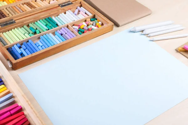 Boş kağıt, yumuşak pasteller ve sanatçının işyerindeki ahşap masaya kalemler çizmek. Tasarım için boşluk