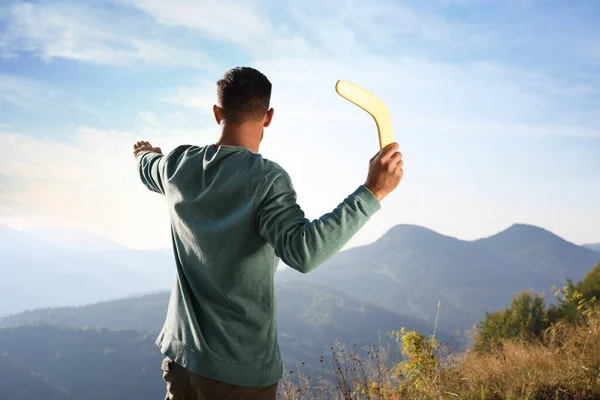 Mężczyzna Rzuca Bumerang Góry Słoneczny Dzień Widok Tyłu — Zdjęcie stockowe