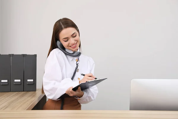 Recepcionista Femenina Con Portapapeles Hablando Por Teléfono Lugar Trabajo — Foto de Stock