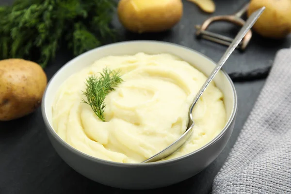 Freshly cooked homemade mashed potatoes on dark grey table, closeup