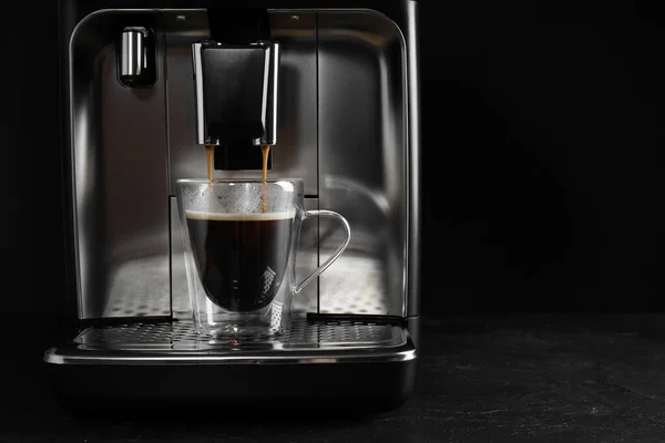 黒を背景にグレーのテーブルの上に現代的なエスプレッソマシンでコーヒーを作る テキストのスペース — ストック写真