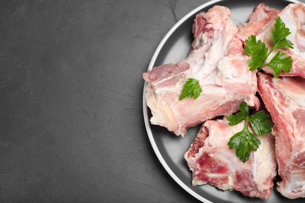 Plate Raw Chopped Meaty Bones Parsley Black Table Top View — Fotografia de Stock