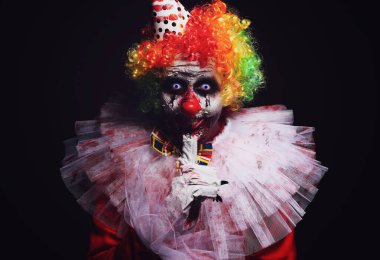 Siyah arka planda korkunç bir palyaço. Cadılar Bayramı partisi kostümü