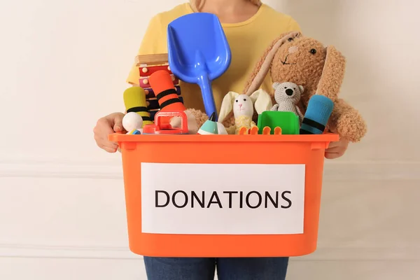 Woman Holding Donation Box Toys Light Background Closeup — 图库照片
