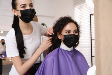 Müşteriyle kuaförde çalışan profesyonel stilist. Coronavirus karantinası sırasında kuaför servisi